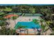 Community pool with lounge chairs and tennis courts in background at 13128 Palmilla Cir, Dade City, FL 33525