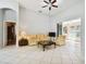 Living room with yellow floral sofa, ceiling fan, and view into the sunroom at 8601 Atmore Ave., North Port, FL 34287