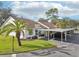 White villa with carport, landscaping, and palm trees at 7631 Bloomingdale Dr, New Port Richey, FL 34654