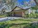 Front view of home showcasing a brown garage door and well-manicured lawn at 2728 Saint Cloud Oaks Dr, Valrico, FL 33594