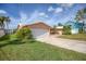 Pink house with a white garage door and lush landscaping at 1301 Sea Gull S Dr, St Petersburg, FL 33707