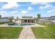 A spacious backyard oasis featuring a sparkling pool, covered patio, and lush landscaping at 7886 9Th S Ave, St Petersburg, FL 33707