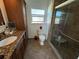 Bathroom featuring granite countertops, wood cabinets, and a tiled shower with glass doors at 7886 9Th S Ave, St Petersburg, FL 33707