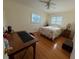 Bedroom featuring hardwood floors, a desk, a ceiling fan, and two bright windows at 7886 9Th S Ave, St Petersburg, FL 33707