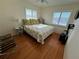 Cozy bedroom featuring hardwood floors, bright windows, and a floral-themed bedspread at 7886 9Th S Ave, St Petersburg, FL 33707
