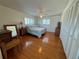 Bedroom with hardwood floors, plantation shutters, ceiling fan, and a closet with louvered doors at 7886 9Th S Ave, St Petersburg, FL 33707