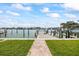 Picturesque view of private boat dock on the water, surrounded by lush greenery and clear skies at 7886 9Th S Ave, St Petersburg, FL 33707