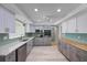 Bright kitchen features gray cabinets, stainless steel appliances, light countertops, and a stylish backsplash at 7886 9Th S Ave, St Petersburg, FL 33707