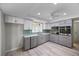 Bright kitchen featuring light gray cabinets, modern appliances, and wood-look floors at 7886 9Th S Ave, St Petersburg, FL 33707