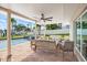 Expansive covered patio with stylish seating, ceiling fans, and views of the inviting pool and serene waterfront at 7886 9Th S Ave, St Petersburg, FL 33707