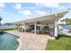 Spacious covered patio with ceiling fans, ample seating, a built-in serving station, and a grill at 7886 9Th S Ave, St Petersburg, FL 33707