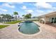 Sparkling swimming pool surrounded by lush landscaping, a covered patio, and serene waterfront views at 7886 9Th S Ave, St Petersburg, FL 33707
