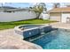 Pool featuring decorative tile work, waterfall feature, and lush green backyard at 7886 9Th S Ave, St Petersburg, FL 33707