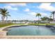 Waterfront pool featuring sparkling water, lush palms, backyard, and clear blue skies at 7886 9Th S Ave, St Petersburg, FL 33707