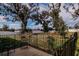 Backyard with black metal fencing, trees, and a patio area at 802 Highgate Oaks Pl, Seffner, FL 33584
