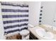 Clean bathroom featuring striped shower curtain and granite vanity at 802 Highgate Oaks Pl, Seffner, FL 33584