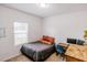 Minimalist bedroom with a cozy bed, wooden desk, and natural light from the window at 802 Highgate Oaks Pl, Seffner, FL 33584