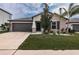 Single-story home with two-car garage and well-manicured lawn at 14906 Imperial Purple Ln, Wimauma, FL 33598