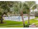 Community pool area with lush landscaping and white fence at 650 Pinellas Point S Dr # 211, St Petersburg, FL 33705