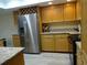 Kitchen features stainless steel refrigerator, light wood cabinets, and granite countertops at 13936 Clubhouse Cir # 13936, Tampa, FL 33618