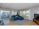 Bright living room with blue sectional sofa, wood floors, and sliding glass doors to a patio at 176 Philadelphia Lot 5 Blvd, Palm Harbor, FL 34684