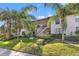 Condo with manicured lawn and well-maintained landscaping, nestled between mature palm trees at 1662 Seascape Cir # 205, Tarpon Springs, FL 34689