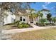 Two-story home featuring a well-manicured front yard with palm trees and ample greenery at 707 Winterside Dr, Apollo Beach, FL 33572