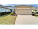 Attached two-car garage with neutral tones and a well-manicured lawn and garden at 707 Winterside Dr, Apollo Beach, FL 33572