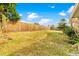 Backyard with a wooden fence, grassy area, and some landscaping at 5621 Moog Rd, New Port Richey, FL 34652