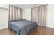 Spacious bedroom with gray bedding and wood floors at 5621 Moog Rd, New Port Richey, FL 34652