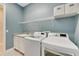 Laundry room with washer, dryer, utility sink, and overhead shelving at 707 Winterside Dr, Apollo Beach, FL 33572