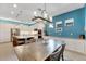 Kitchen dining area with farmhouse table and modern chandelier at 707 Winterside Dr, Apollo Beach, FL 33572