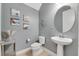 Stylish powder room with a pedestal sink and a round mirror at 707 Winterside Dr, Apollo Beach, FL 33572