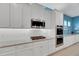 Modern kitchen with white cabinets, granite counters, and stainless steel appliances at 707 Winterside Dr, Apollo Beach, FL 33572