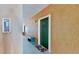 Building hallway with green door and decorative bench at 2717 Via Cipriani # 622B, Clearwater, FL 33764