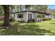 Cozy home showcasing well-manicured lawn and garden with mature trees at 1802 E Hamilton Ave, Tampa, FL 33610