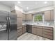A modern kitchen features stainless steel appliances, sleek counters, and warm cabinetry at 1802 E Hamilton Ave, Tampa, FL 33610