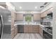 This kitchen features stainless steel appliances, light wood floors, and light tan cabinets at 1802 E Hamilton Ave, Tampa, FL 33610