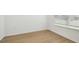 A simple bedroom features wood floors, a window, neutral tones, and a bright atmosphere at 6681 Michael Favor Way, Wesley Chapel, FL 33545