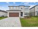 Charming two-story home with a landscaped yard and a welcoming, brick-paved driveway at 6681 Michael Favor Way, Wesley Chapel, FL 33545