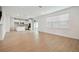 Bright open-plan living space with wood floors connecting to a modern white kitchen at 6681 Michael Favor Way, Wesley Chapel, FL 33545