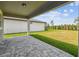 Covered patio with stone pavers overlooks the spacious, well-maintained backyard at 6681 Michael Favor Way, Wesley Chapel, FL 33545