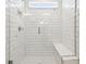 Modern shower features white subway tile, a glass door and built in bench at 6681 Michael Favor Way, Wesley Chapel, FL 33545