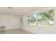 Sunlit living room featuring a large window and front door views of the neighborhood at 7344 Live Oak Ln, New Port Richey, FL 34653