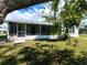 Home exterior showcasing a screened porch and yard at 3233 Lenwood Dr, New Port Richey, FL 34655