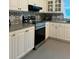 Modern kitchen with white cabinets, black and white patterned backsplash, and stainless steel appliances at 1218 Hummingbird Ln, Brandon, FL 33511