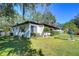 Ranch-style home with a spacious lawn and mature trees at 1802 E Hamilton Ave, Tampa, FL 33610