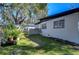 Fenced backyard with a grassy area and mature trees at 1802 E Hamilton Ave, Tampa, FL 33610