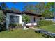 Landscaped front yard with mature trees and shrubs at 1802 E Hamilton Ave, Tampa, FL 33610