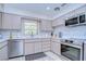 Updated kitchen with stainless steel appliances and tile backsplash at 1802 E Hamilton Ave, Tampa, FL 33610